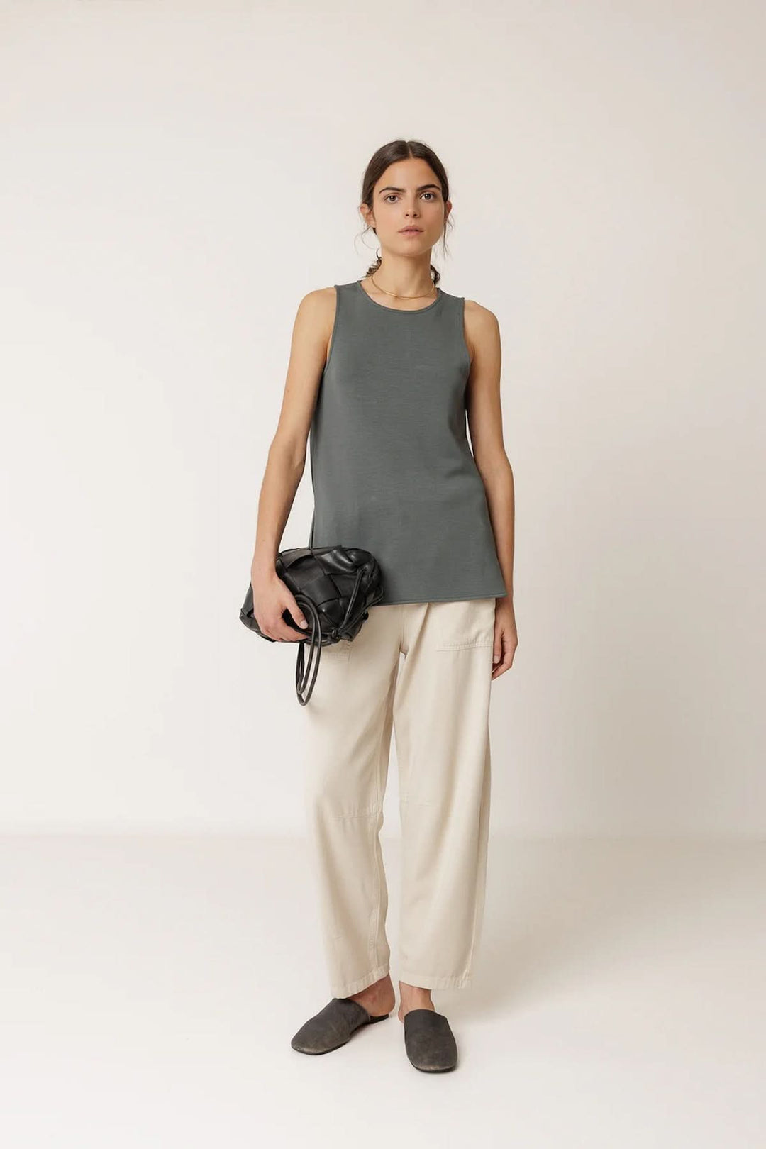 Femme portant un débardeur minimaliste à coupe fluide avec un pantalon, style moderne et épuré.