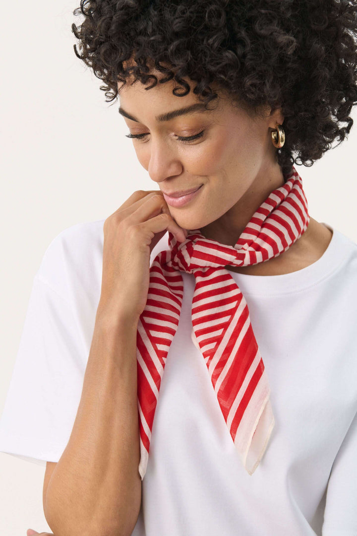 Foulard Phi à rayures rouges, porté avec élégance autour du cou pour une touche de fraîcheur.
