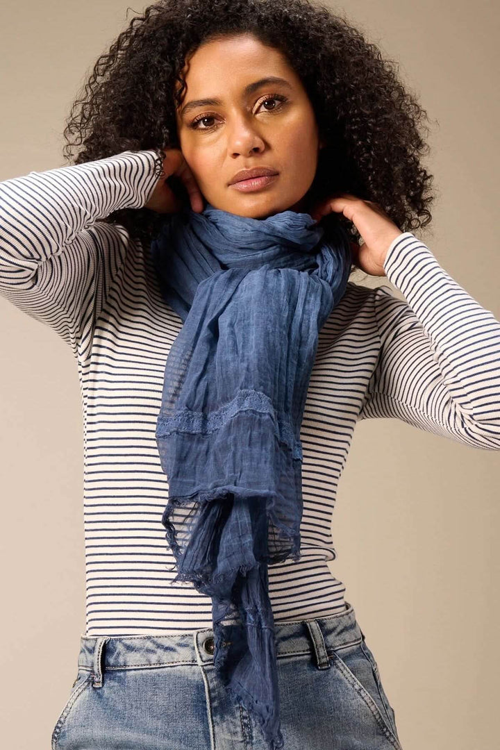 Femme portant un foulard en coton bleu, style léger et fluide, multidimensionnel, 120 x 200 cm, élégant et naturel.
