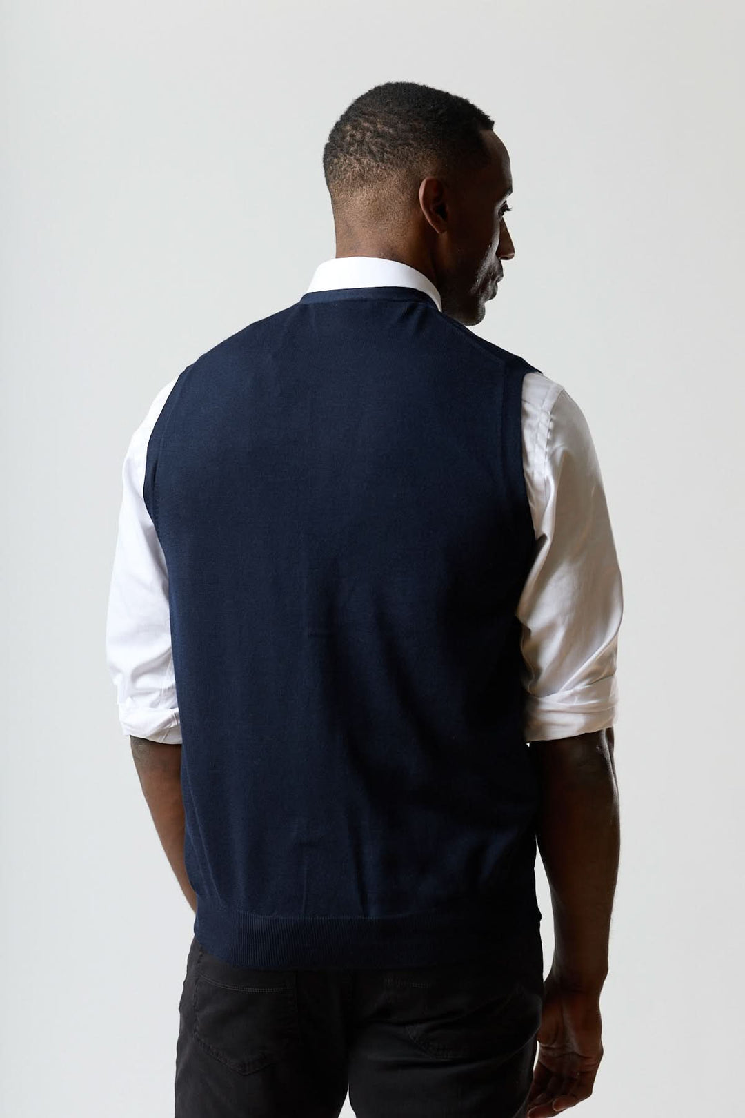 Homme portant un Gilet en laine mérinos à col en V, vue de dos, élégant et sophistiqué, parfait pour un style raffiné et ajusté.
