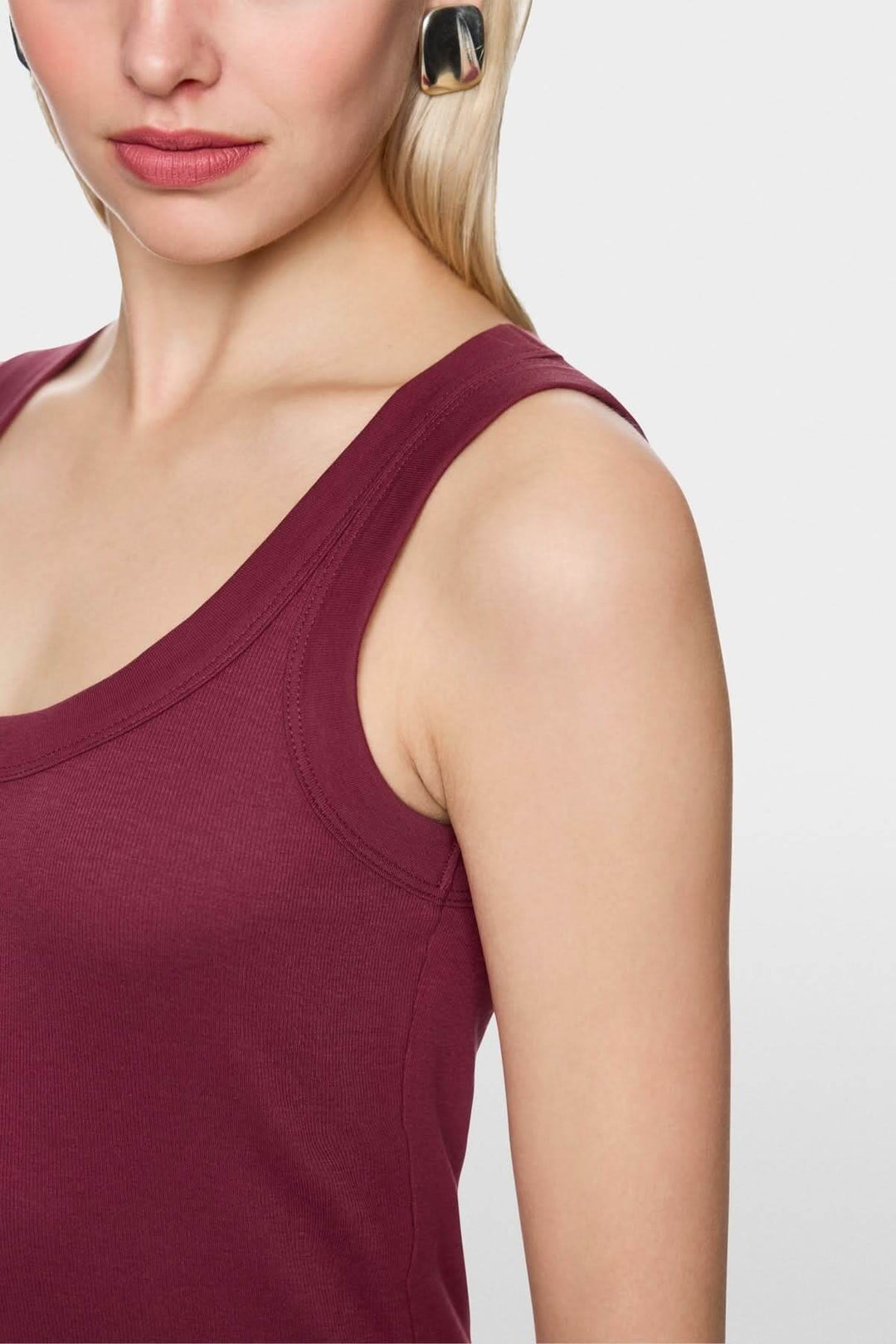 Haut sans manches en coton côtelé avec finitions contrastées, femme portant un débardeur pour un style minimaliste et confortable.