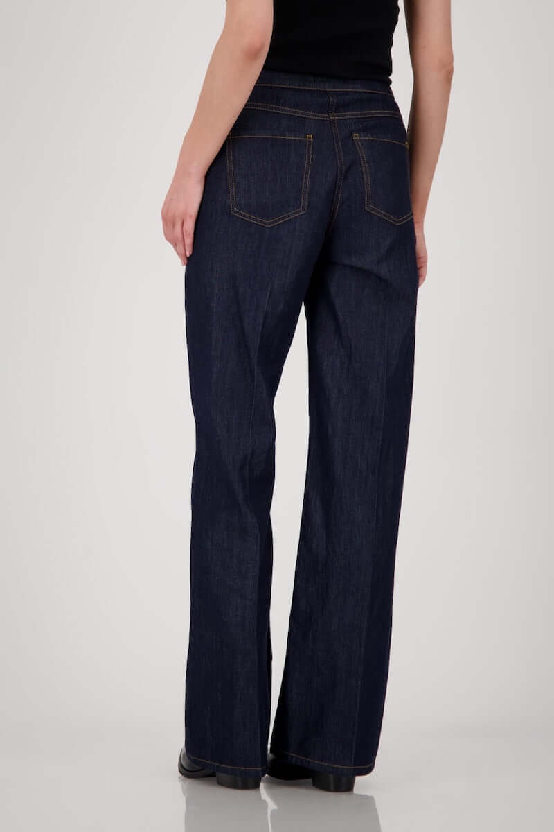 Jean taille haute en denim brut, coupe droite et ample, coutures visibles, parfait pour un look moderne et confortable.