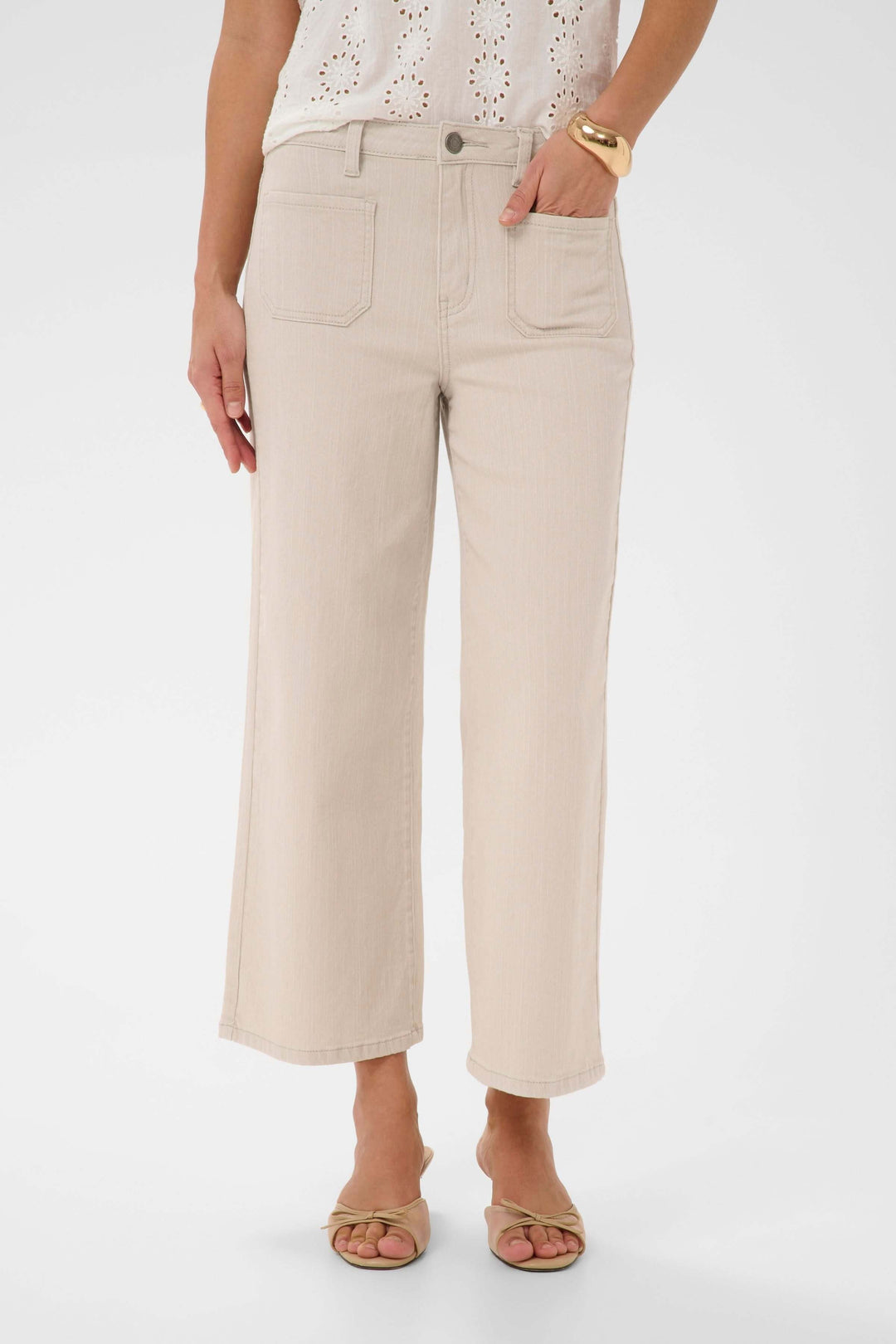 Jeans Brook à jambe droite beige avec taille structurée, porté avec un haut blanc pour un style polyvalent et confortable.