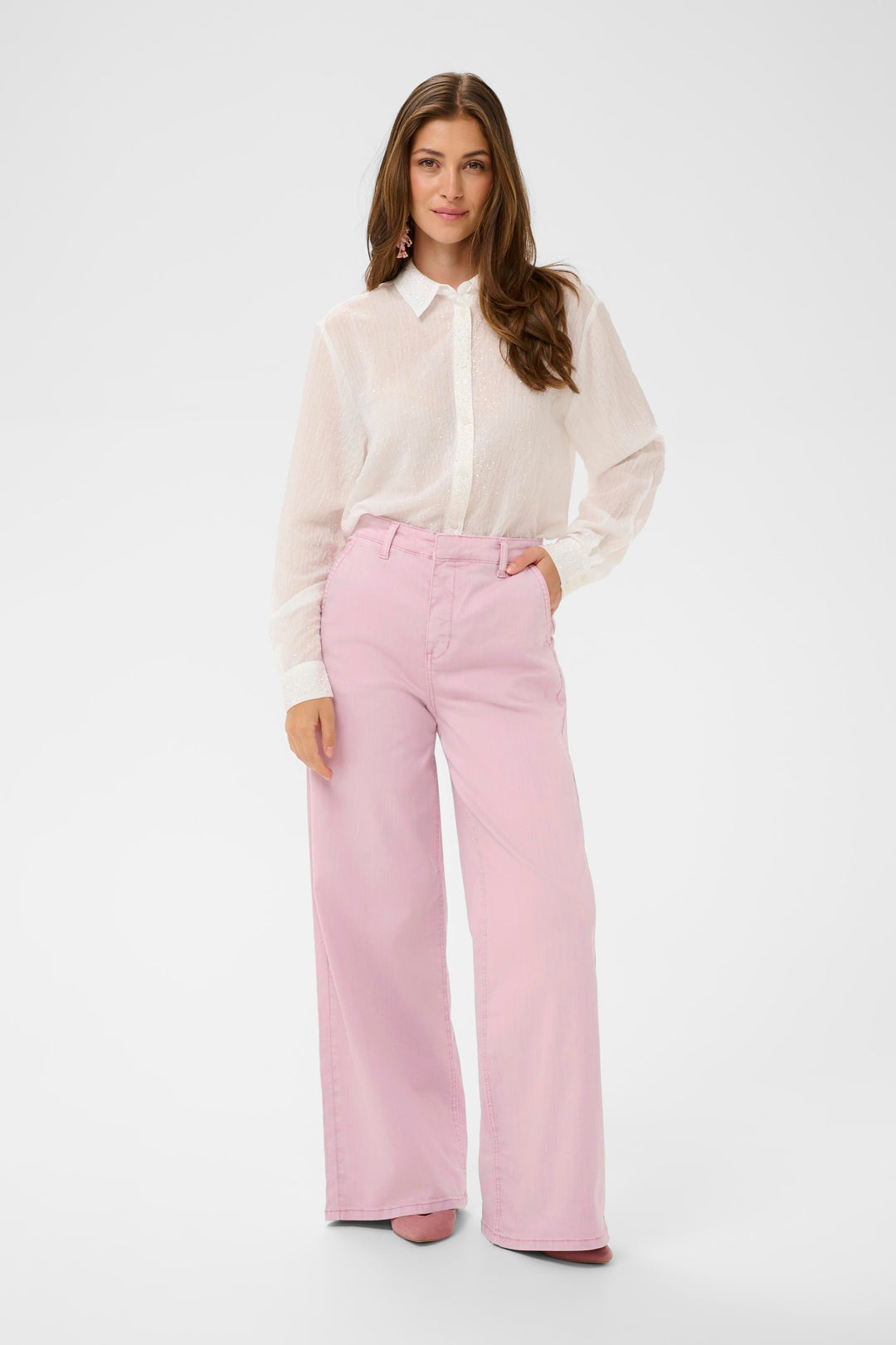 Modèle portant le Jeans Visti rose à jambe large avec une blouse blanche, coupe ample pour un style décontracté et élégant.