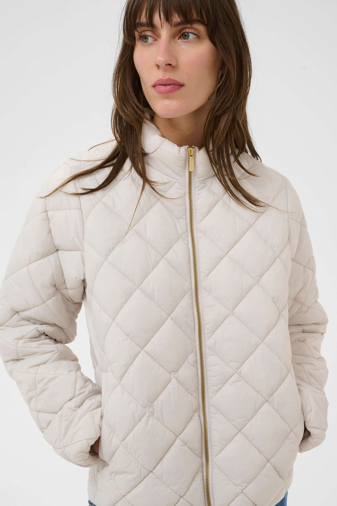 Femme portant un Manteau Olia matelassé avec col montant et fermeture éclair, idéal pour une allure moderne et pratique.
