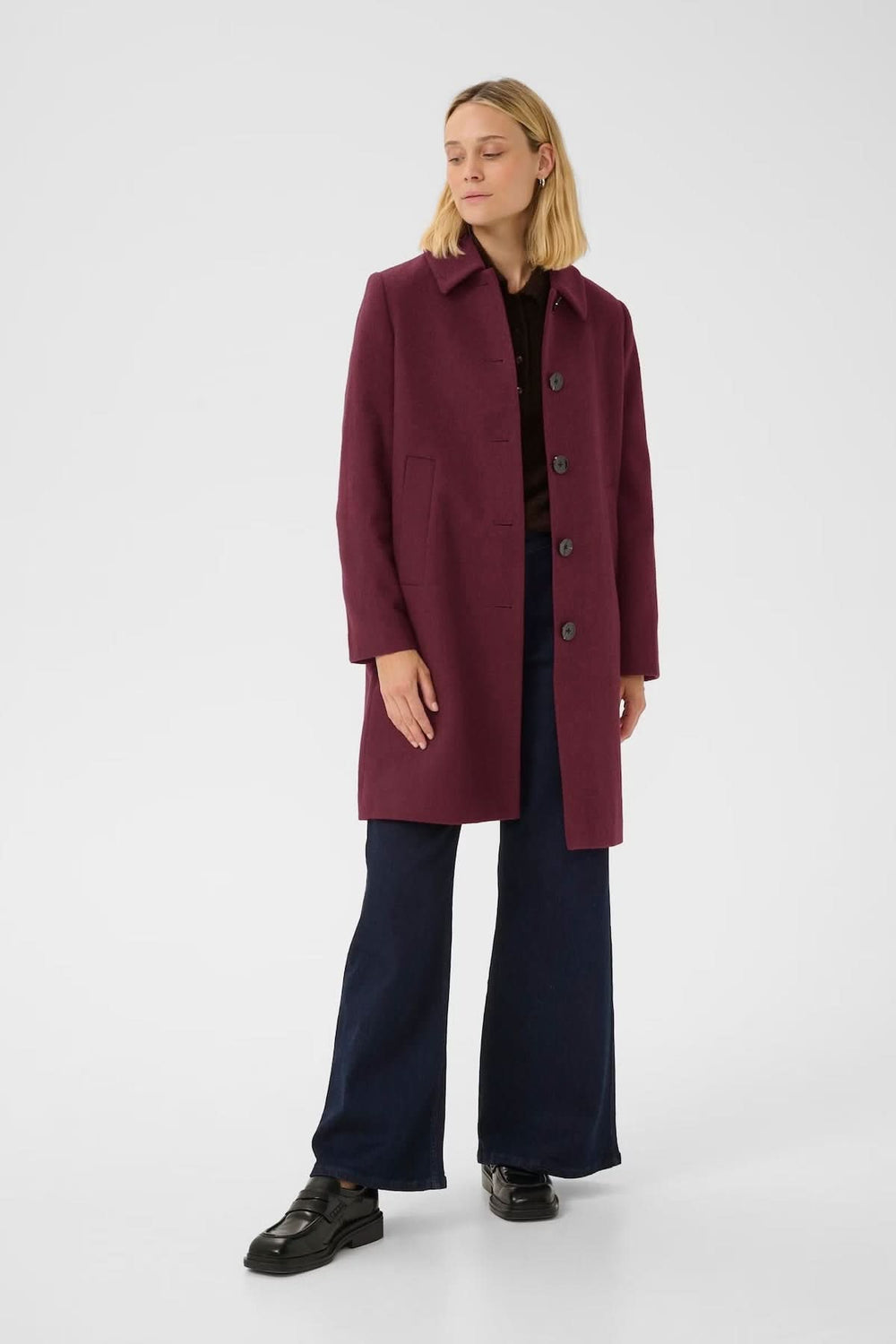 Manteau en laine Kamillas, coupe droite, col chemise, couleur bordeaux, chic pour l'hiver, porté avec pantalon habillé.