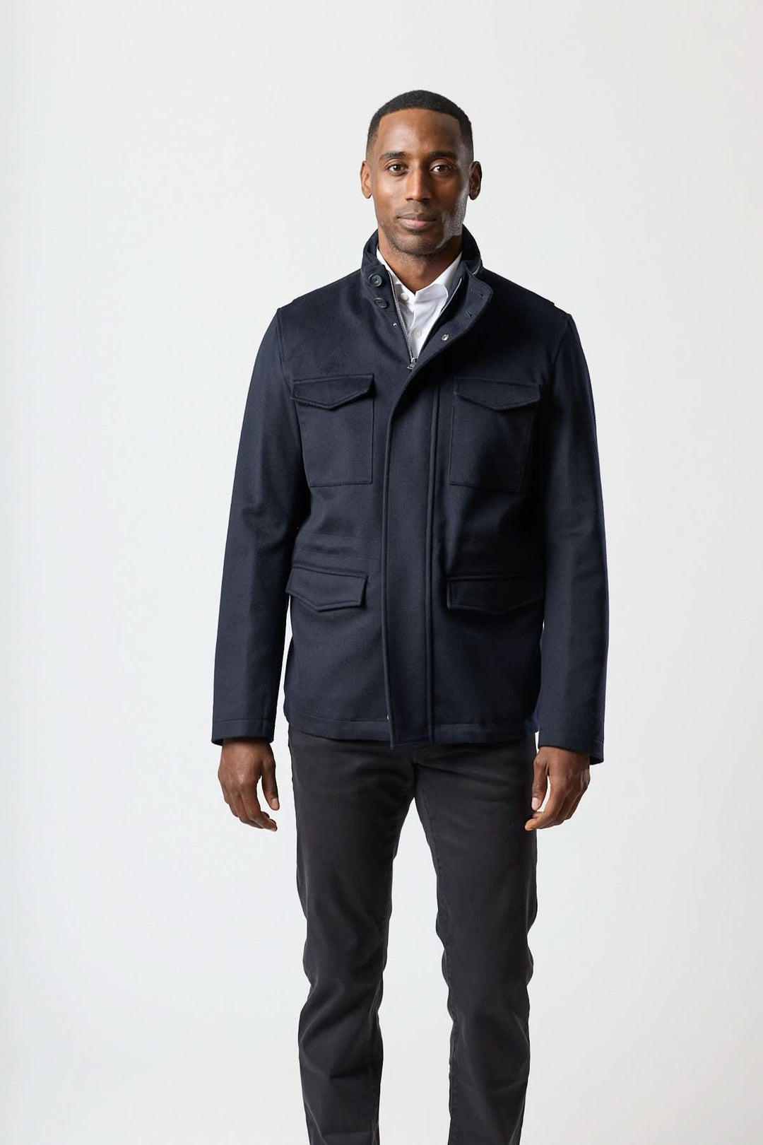 Homme portant un manteau en laine à quatre poches avec col montant et fermeture zippée-boutonnée, convenant à un style smart-casual.