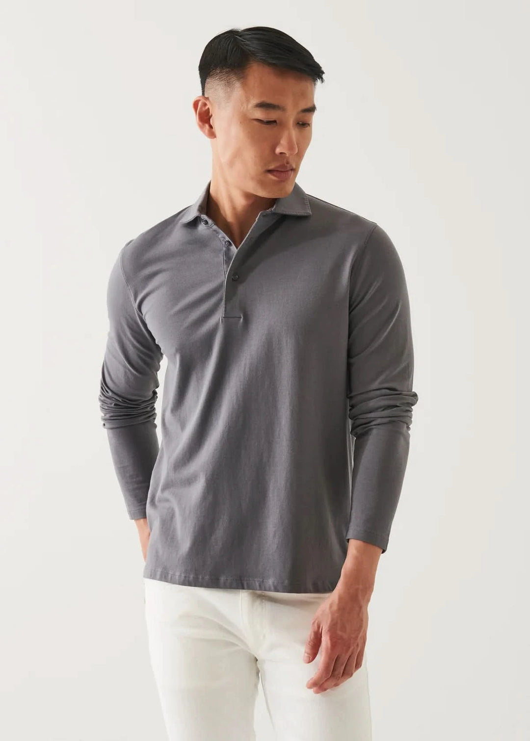Homme portant un polo de coton stretch à manches longues en gris avec un col surpiqué.