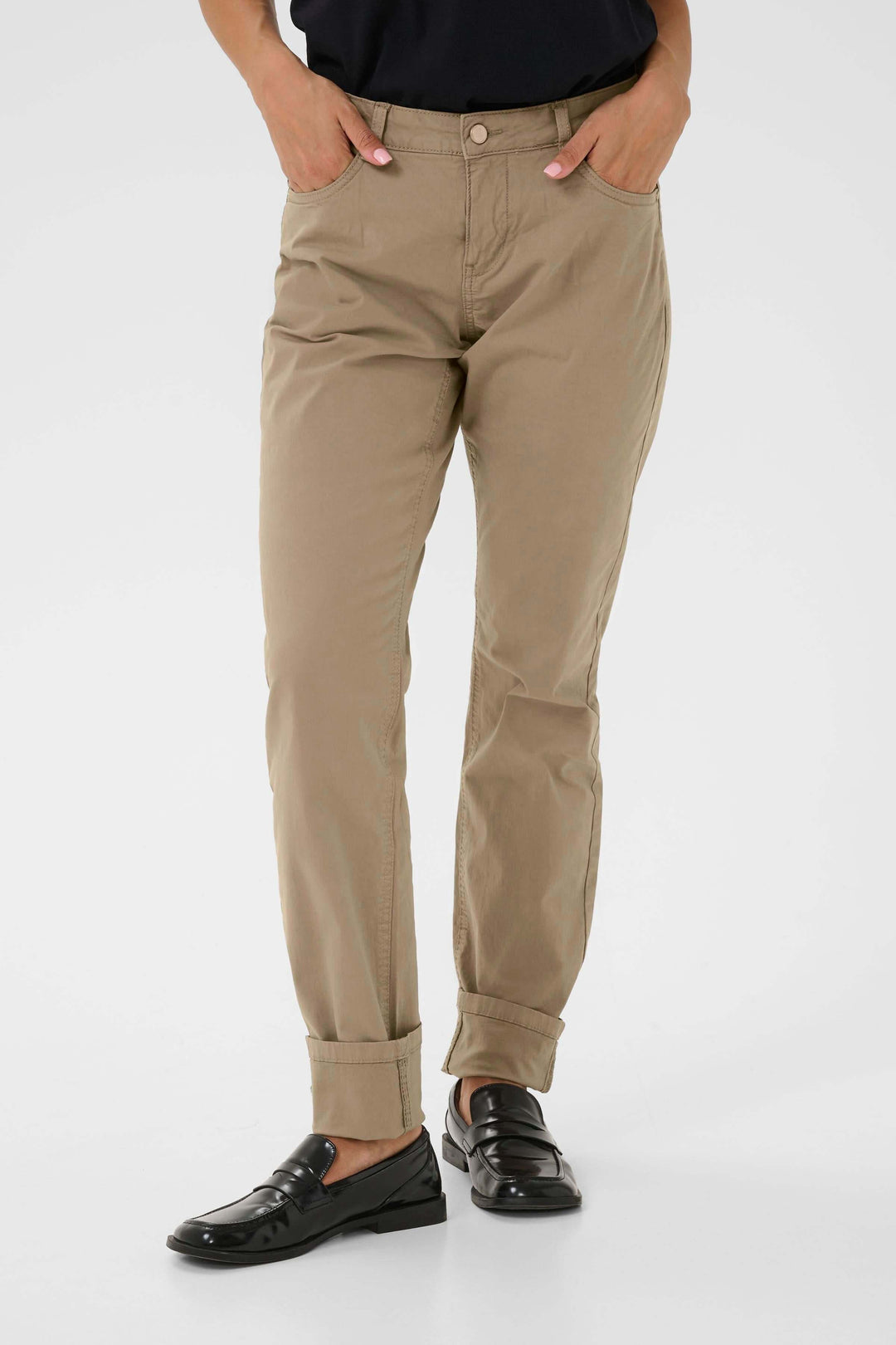 Pantalon Berta beige, coupe droite, revers en bas, style décontracté chic, porté avec chemise noire.