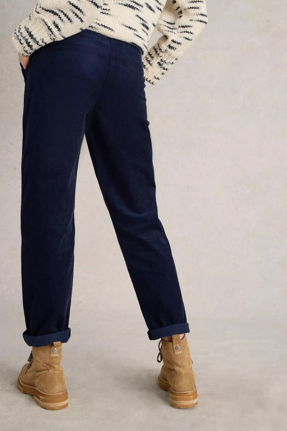 Homme portant le Pantalon Twister en velours côtelé bleu avec poches plaquées, accompagné d'un chandail en maille, look casual-chic.