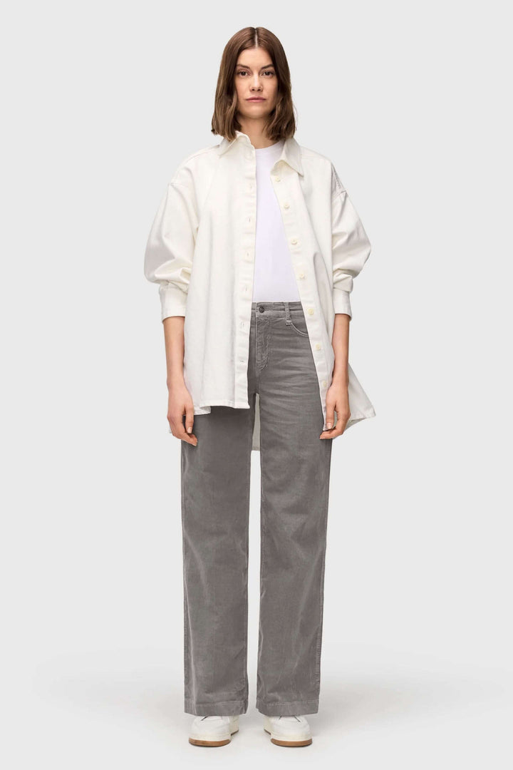 Femme portant un Pantalon Wide en velours côtelé à jambe large gris avec chemise blanche, style automnal élégant et décontracté.
