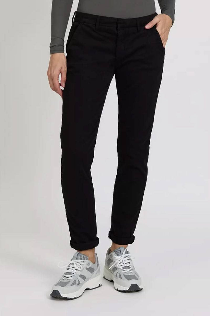 Pantalon chino Sandy noir porté avec des sneakers, mettant en avant une coupe élégante et décontractée.