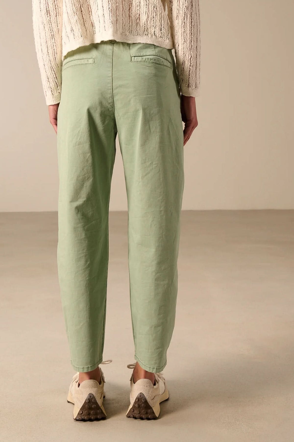 Vue arrière d'un pantalon à coupe décontractée avec taille élastique vert menthe, porté avec un pull beige.