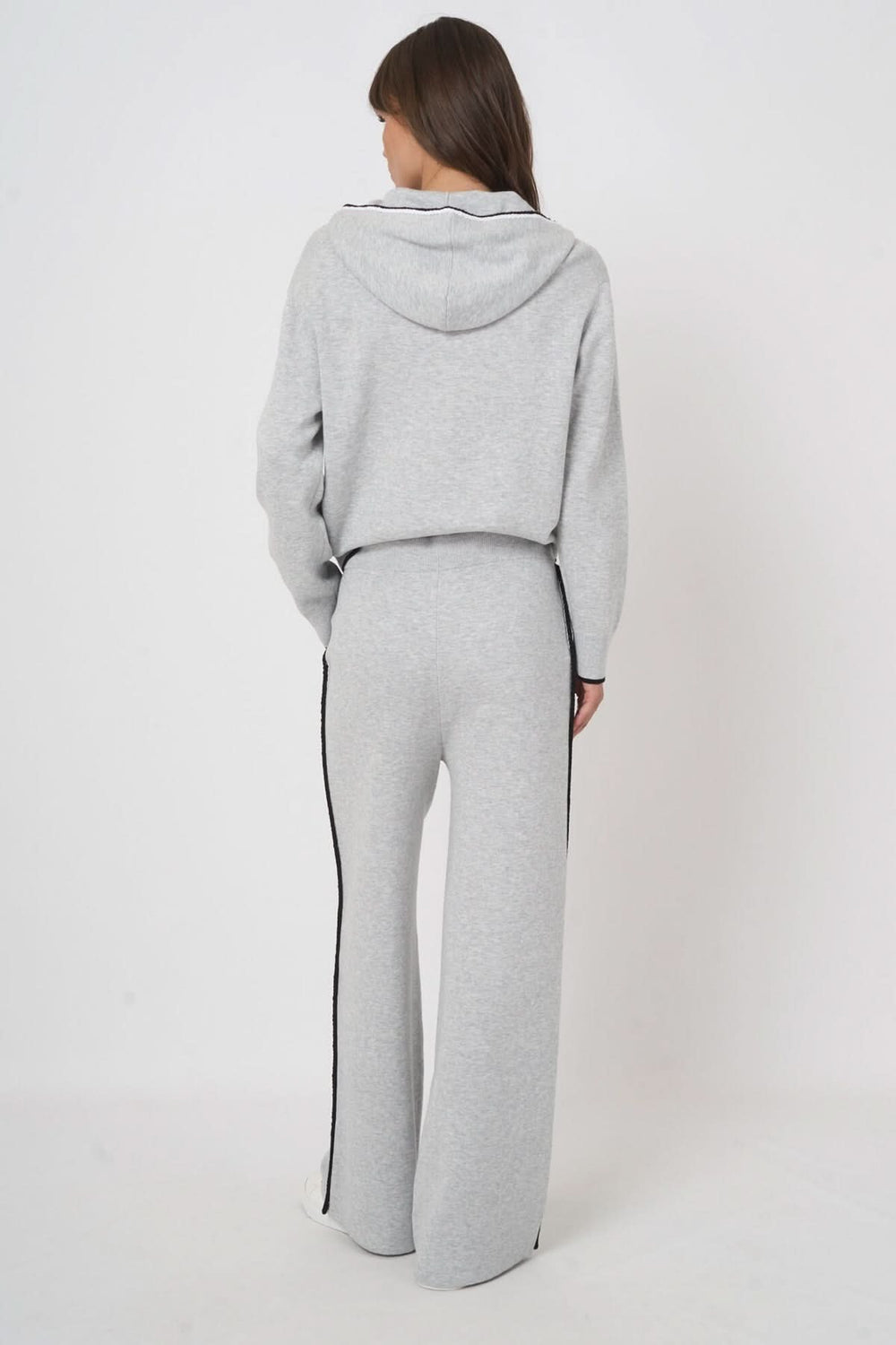 Vue arrière d'un modèle portant un pantalon détente en tricot gris avec coupe droite et cordons de serrage. Style décontracté et moderne.