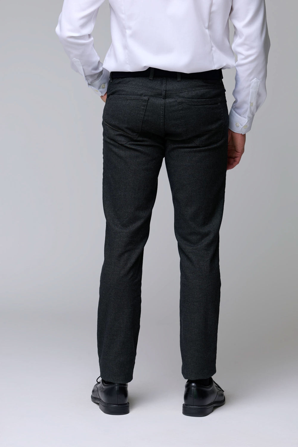 Homme portant un pantalon en laine extensible, coupe droite, de dos, idéal bureau et occasions habillées, mettant en valeur l'élégance classique.