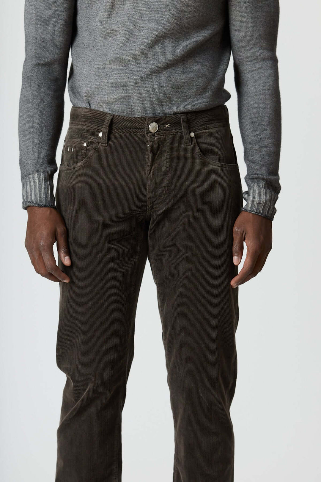 Pantalon en velours côtelé cinq poches Michelangelo en noir avec un pull gris, style casual chic hivernal.