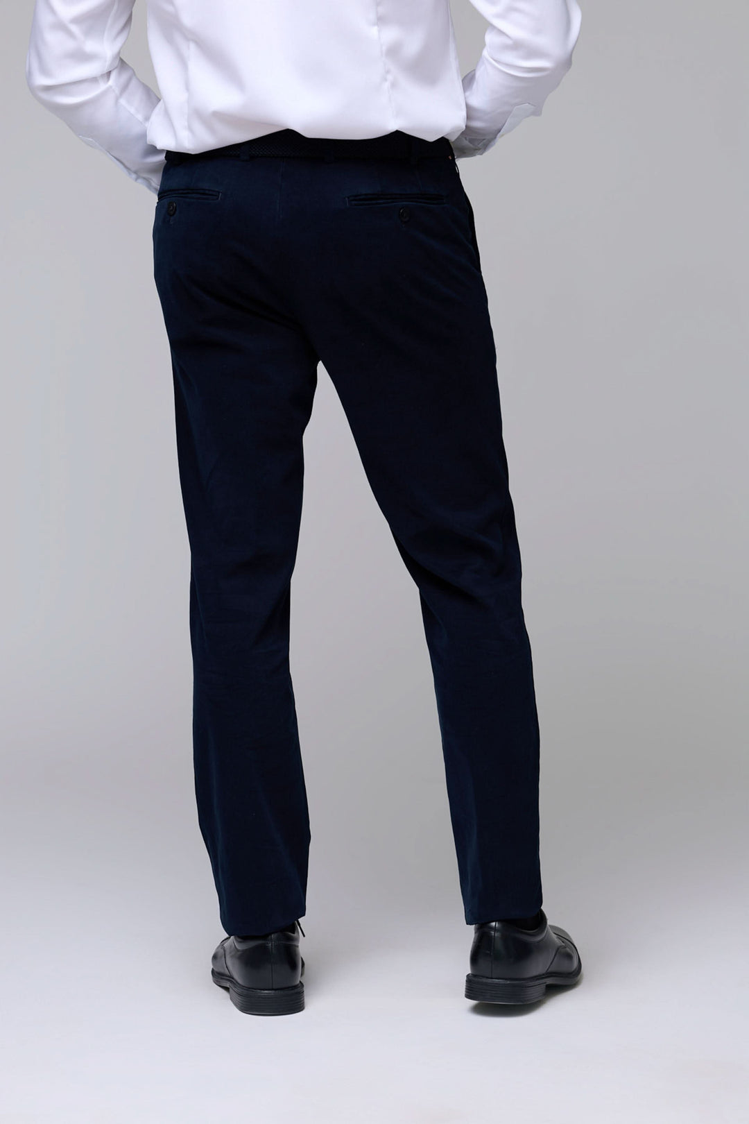 Homme portant un Pantalon en velours côtelé fin bleu marine avec coupe ajustée et cinq poches, élégant et confortable pour le quotidien.