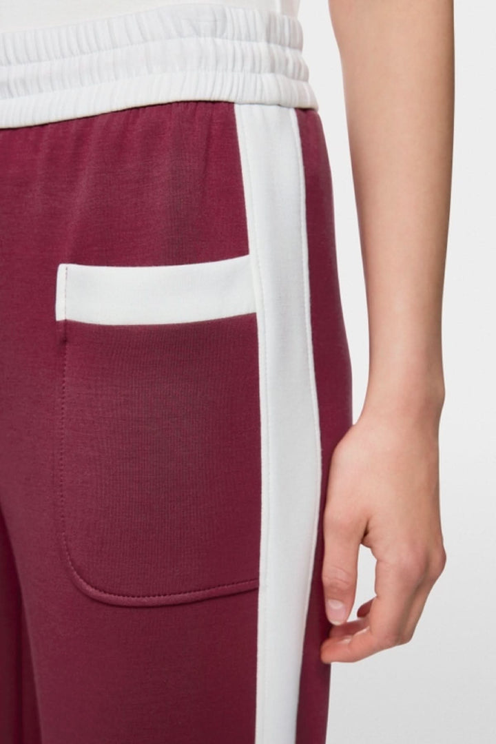 Gros plan sur le Pantalon à enfiler Washington bordeaux avec rayures blanches contrastées et poche latérale, taille jogging élastique.