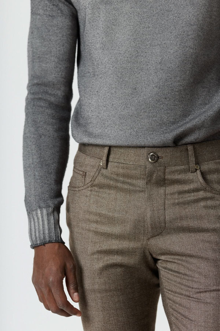 Homme portant un pantalon habillé 5 poches en laine avec pull gris, Corneliani, coupe ajustée et design élégant.