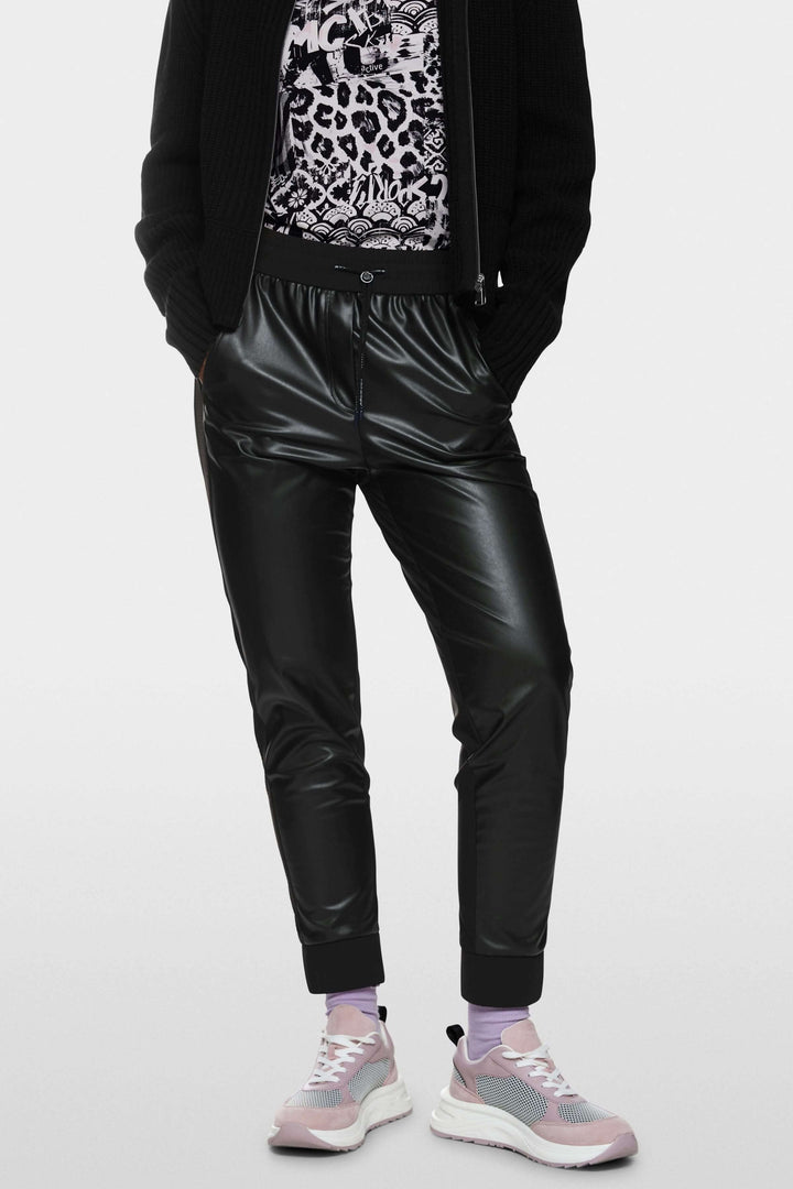 Pantalon habillé Rhodos en cuir effet sportswear, avec taille élastique et coupe fuselée, style urbain avec baskets modernes.