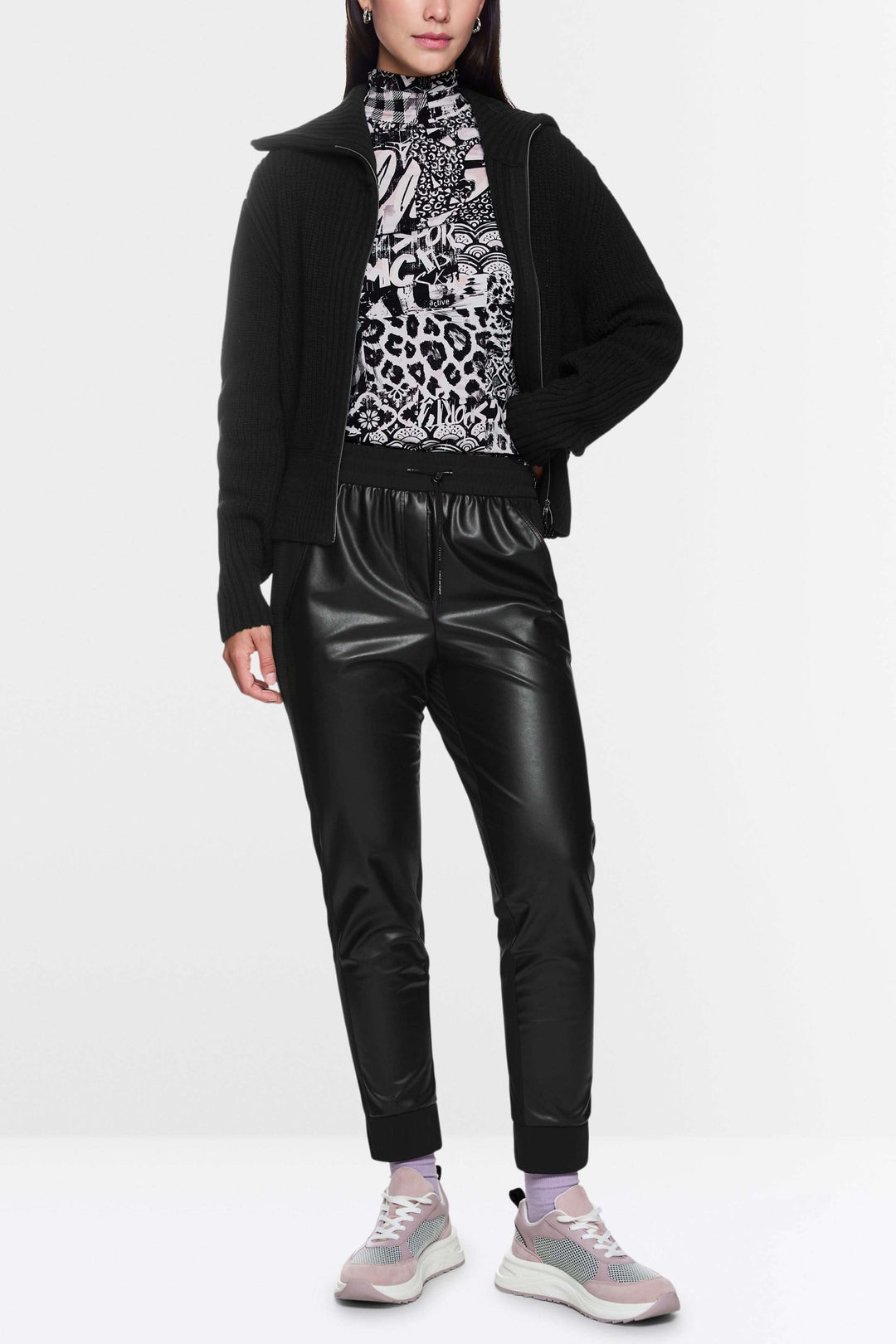 Pantalon habillé Rhodos en effet cuir avec taille élastique et coupe fuselée, style tendance avec baskets et veste noire.