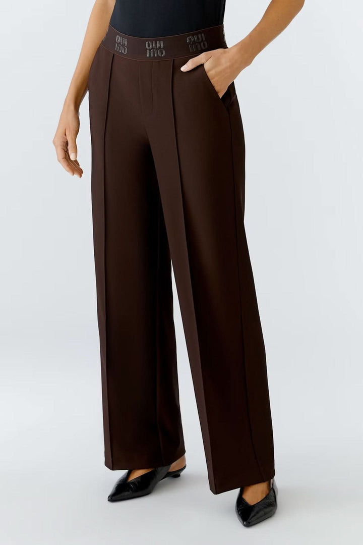Pantalon à jambe large en jersey technique marron avec taille haute élastique, modèle élégant et confortable, style moderne.
