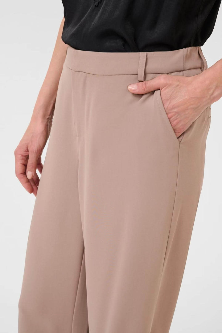 Pantalon à jambe large beige avec coupe fluide et taille régulière, offrant élégance et confort optimal, idéal pour un look sophistiqué.