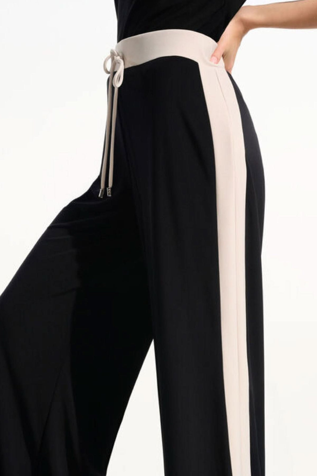 Pantalon à jambe large fluide noir avec taille contrastante et cordon ajustable, offrant un look décontracté et raffiné.