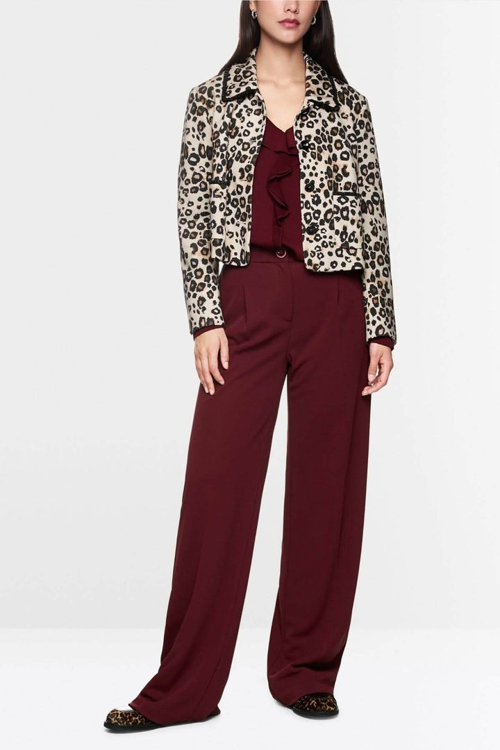Pantalon jambes larges bordeaux porté avec veste imprimée léopard, style élégant et fluide pour une silhouette structurée.