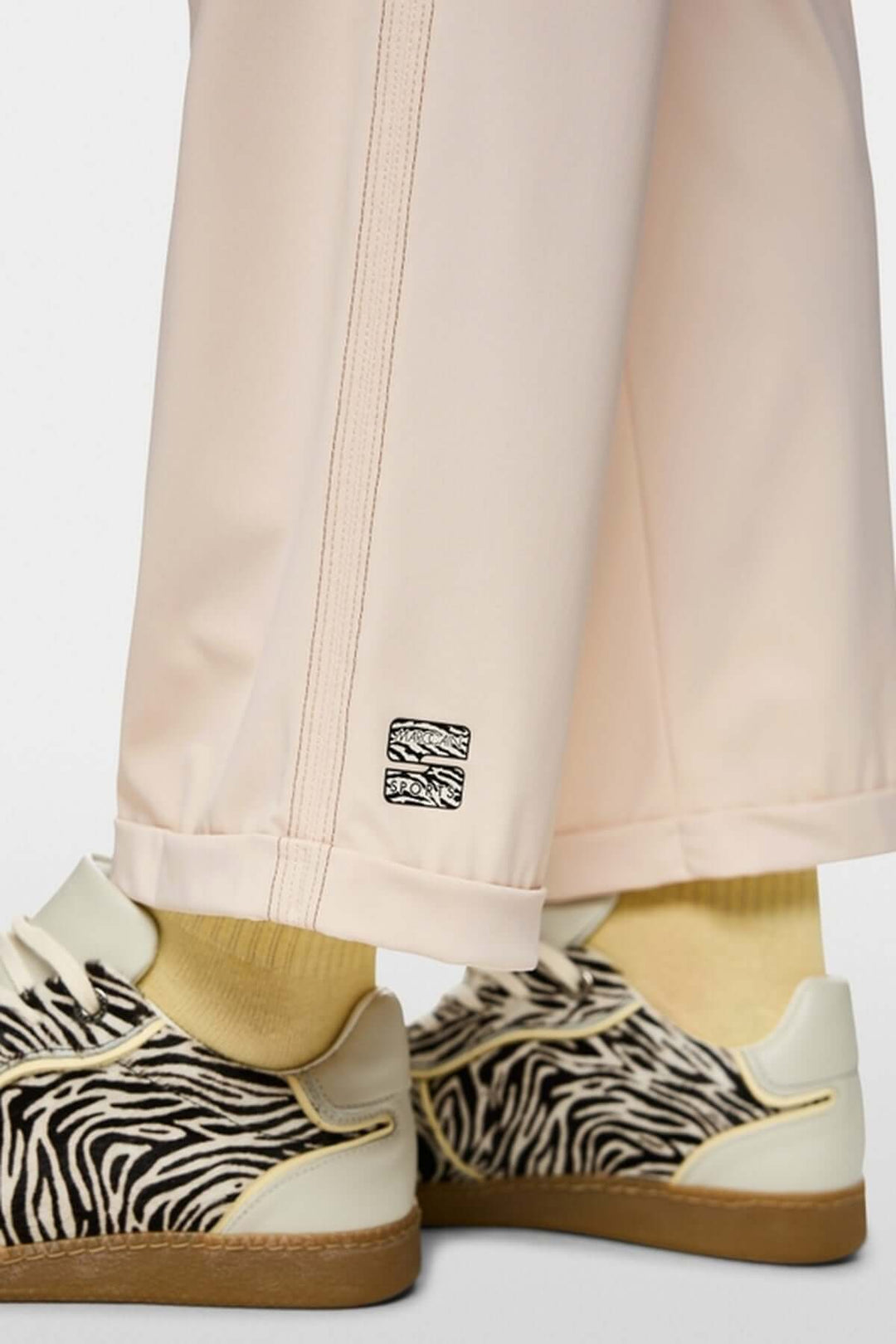 Pantalon léger WUXI avec ourlet retourné et bande latérale, montré avec des chaussures à motif zèbre et chaussettes jaunes.