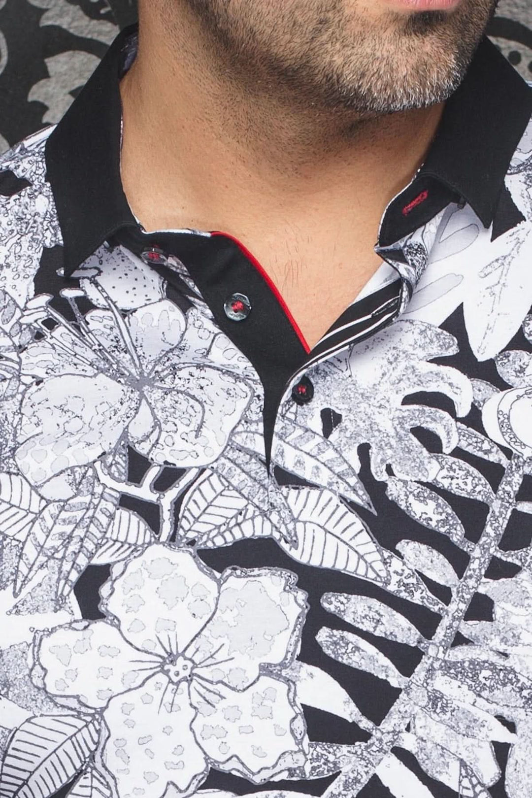 Polo Bennett à imprimé floral noir et blanc avec col contrastant noir et rouge, style contemporain.