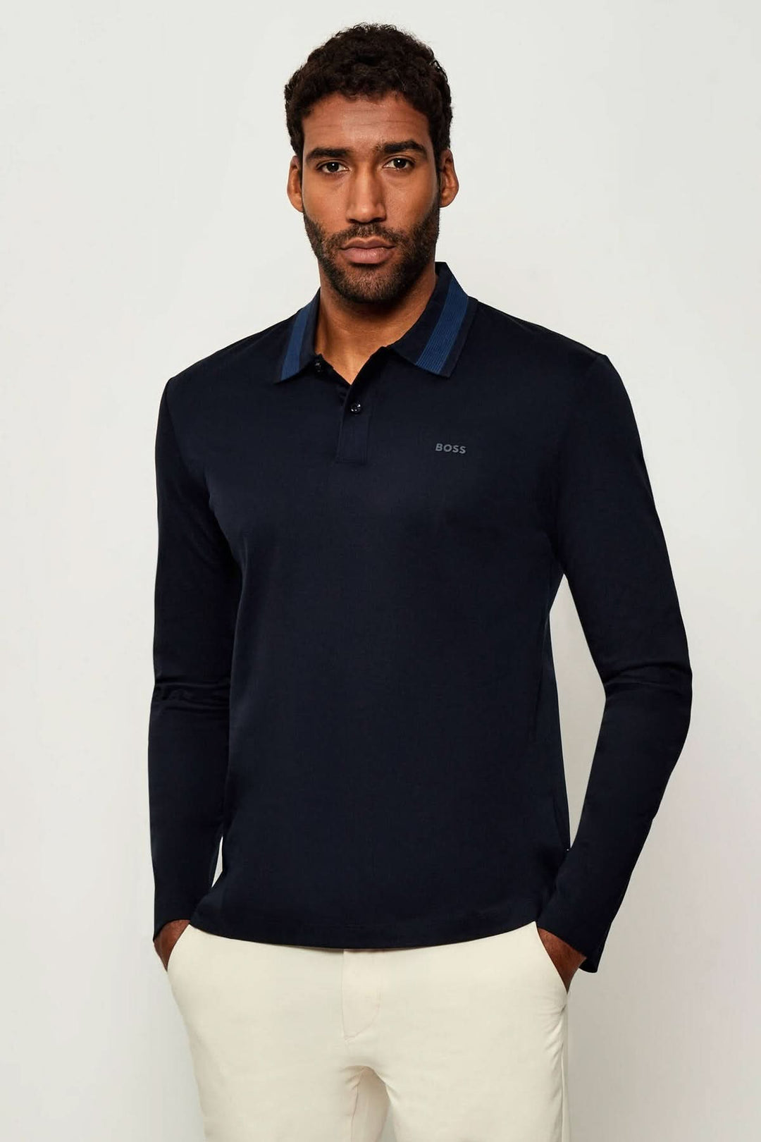 Homme portant un Polo slim fit à manches longues BOSS avec col côtelé bleu, confectionné en coton respirant, coupe ajustée élégante.