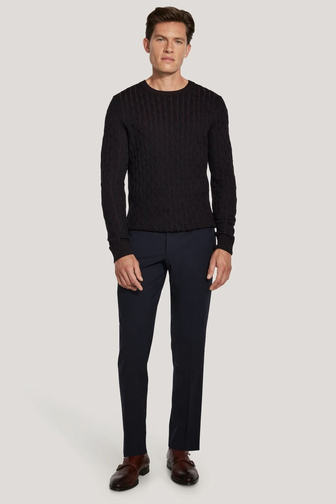 Homme portant un pull ras du cou torsadé en laine mérinos vanisée, tricot vanisé moderne avec coupe élégante, style polyvalent.