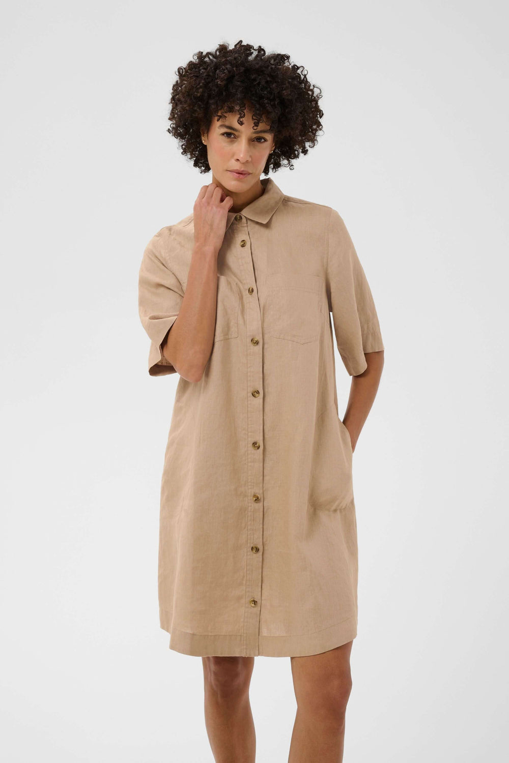 Femme portant la robe chemise en lin Sardiae, coupe droite avec fermeture boutonnée, style décontracté et soigné.