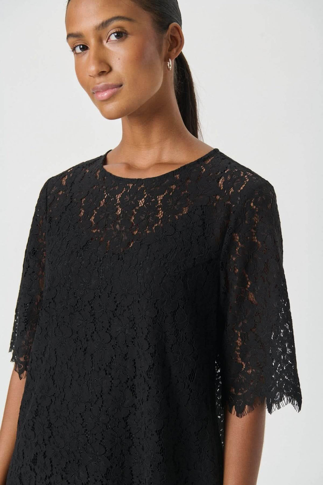 Robe en dentelle Vienne, une élégante robe noire à manches semi-transparentes et coupe évasée, idéale pour soirée chic.
