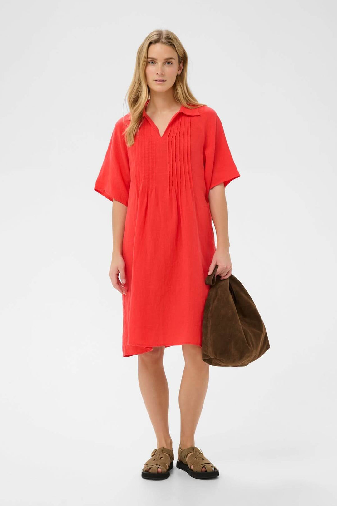 Femme portant la Robe en lin Ayla rouge, coupe droite, avec des détails plissés, tenue décontractée élégante.
