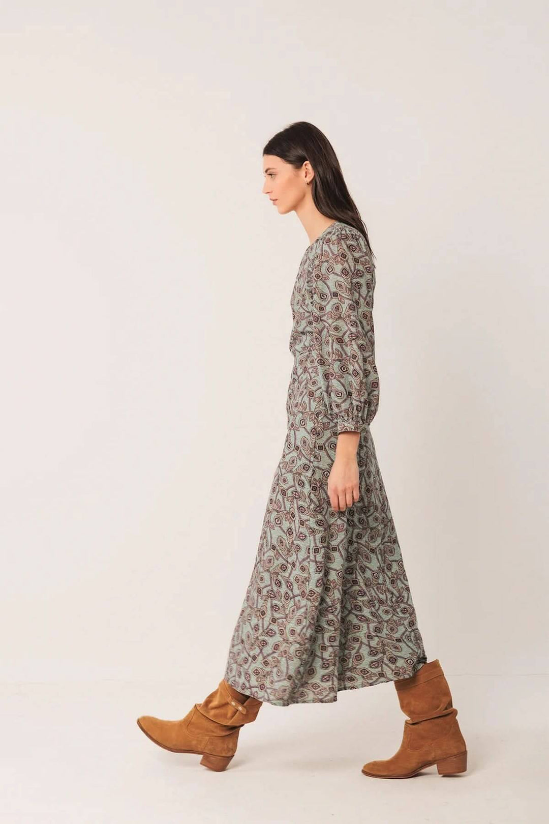 Robe longue au motif géométrique avec manches bouffantes et bottes en daim pour un style bohème chic.