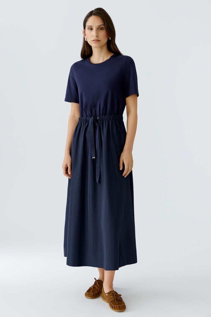Robe midi à taille ajustable en bleu avec manches courtes et taille élastiquée, parfaite pour un style minimaliste et confortable.