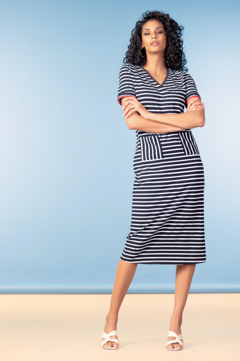 Femme portant une robe rayée à encolure en V, manches courtes, coupe droite, tombé naturel, idéale pour un look estival décontracté.