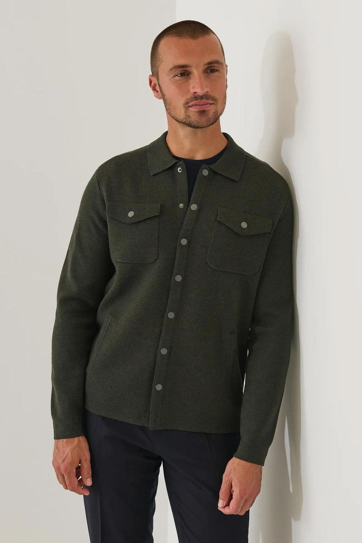 Homme portant une surchemise en laine mérinos extra-fine à boutons-pression, couleur sombre élégante et style moderne décontracté.