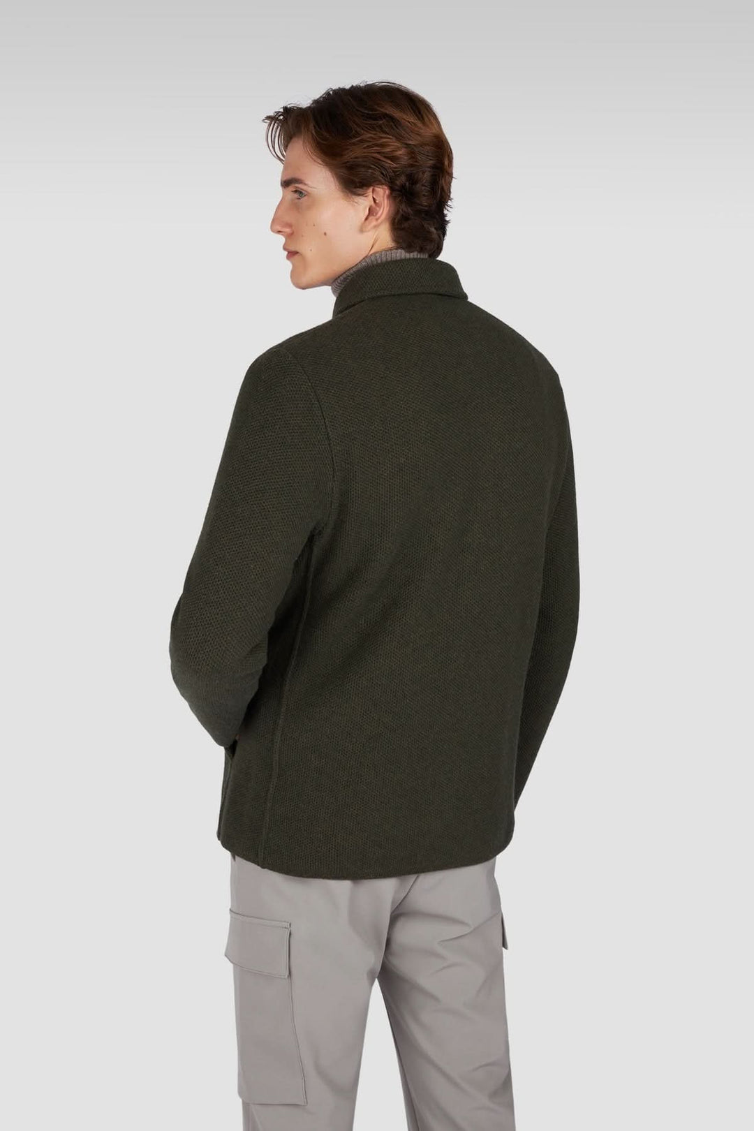 Homme portant une surchemise en laine texturée avec poches plaquées, vue de dos, sur fond gris.