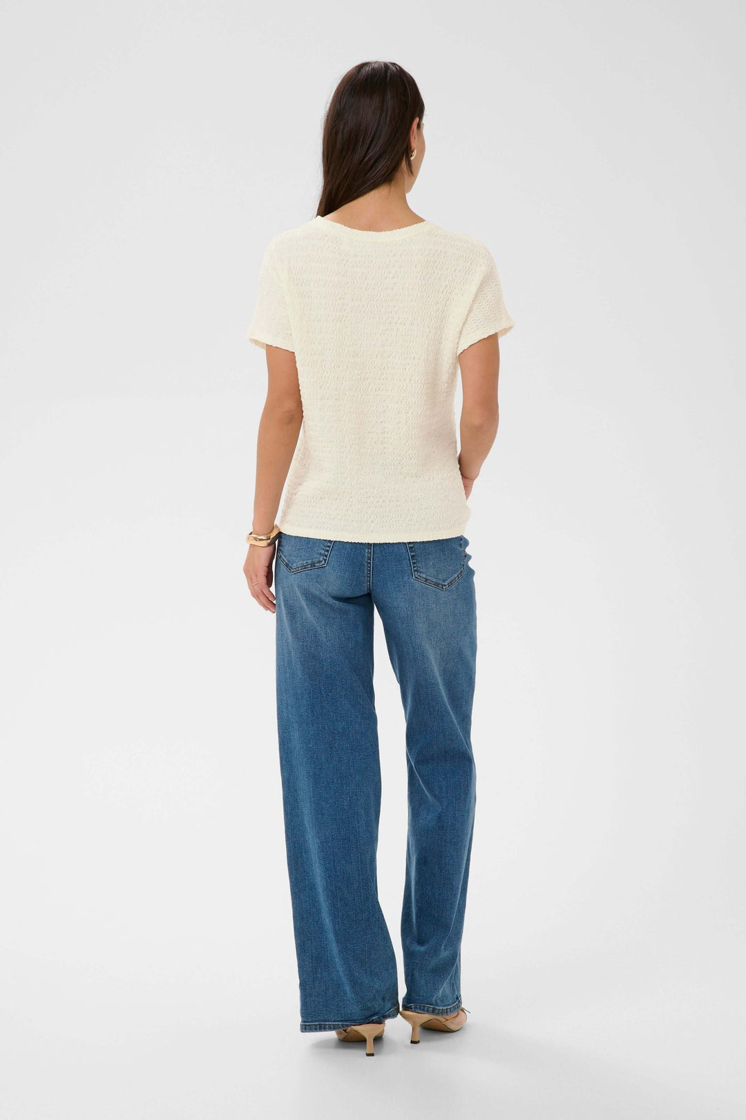 Vue arrière du T-shirt Felecity texturé à manches courtes porté avec un jean, montrant une silhouette simple et élégante.