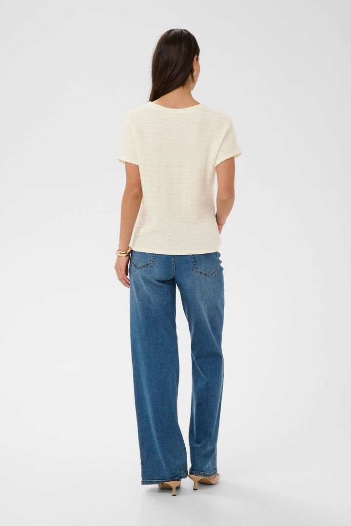 Vue arrière du T-shirt Felecity texturé à manches courtes porté avec un jean, montrant une silhouette simple et élégante.