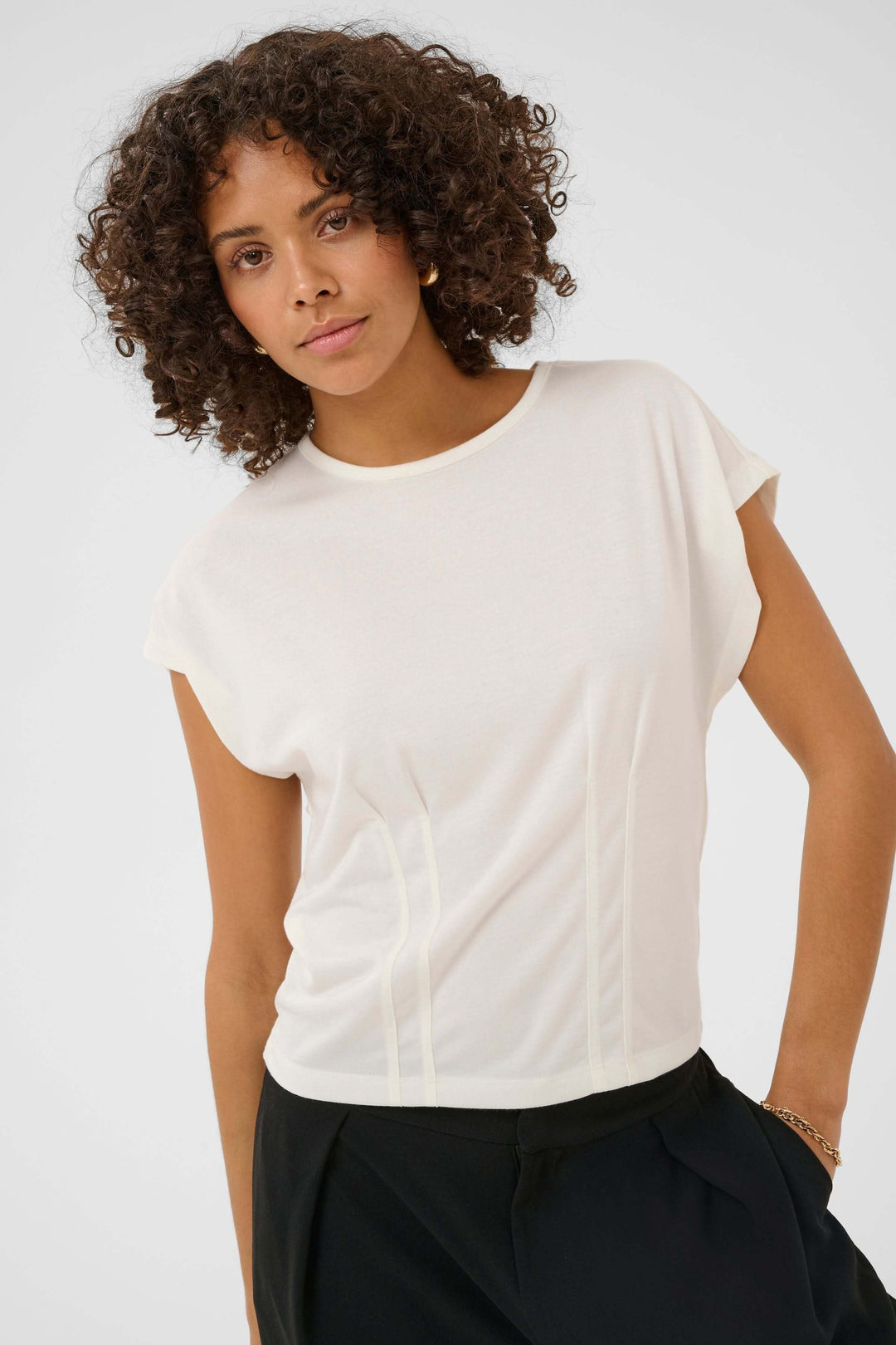T-shirt Lise fluide à manches courtes avec détails structurés, encolure ronde, coupe droite épurée, sur modèle féminin.