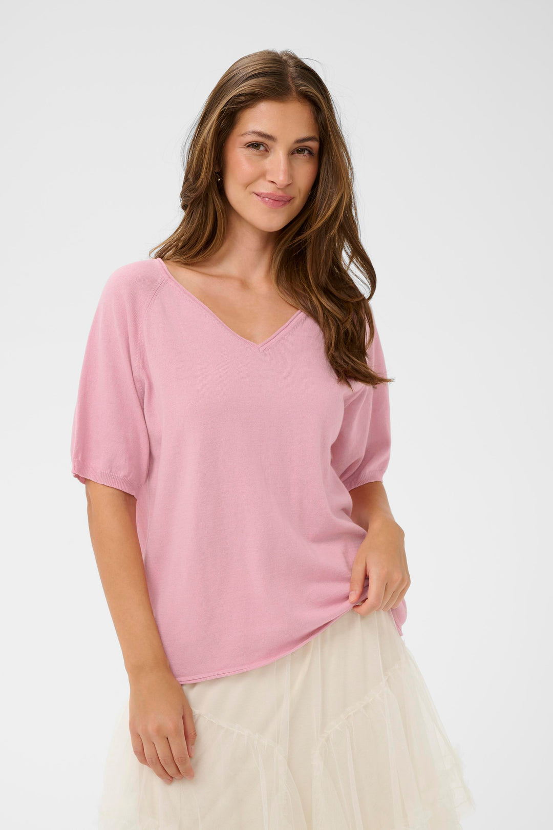 T-shirt Romane avec encolure en V et manches amples, style décontracté, couleur rose pâle, porté par une femme souriante.