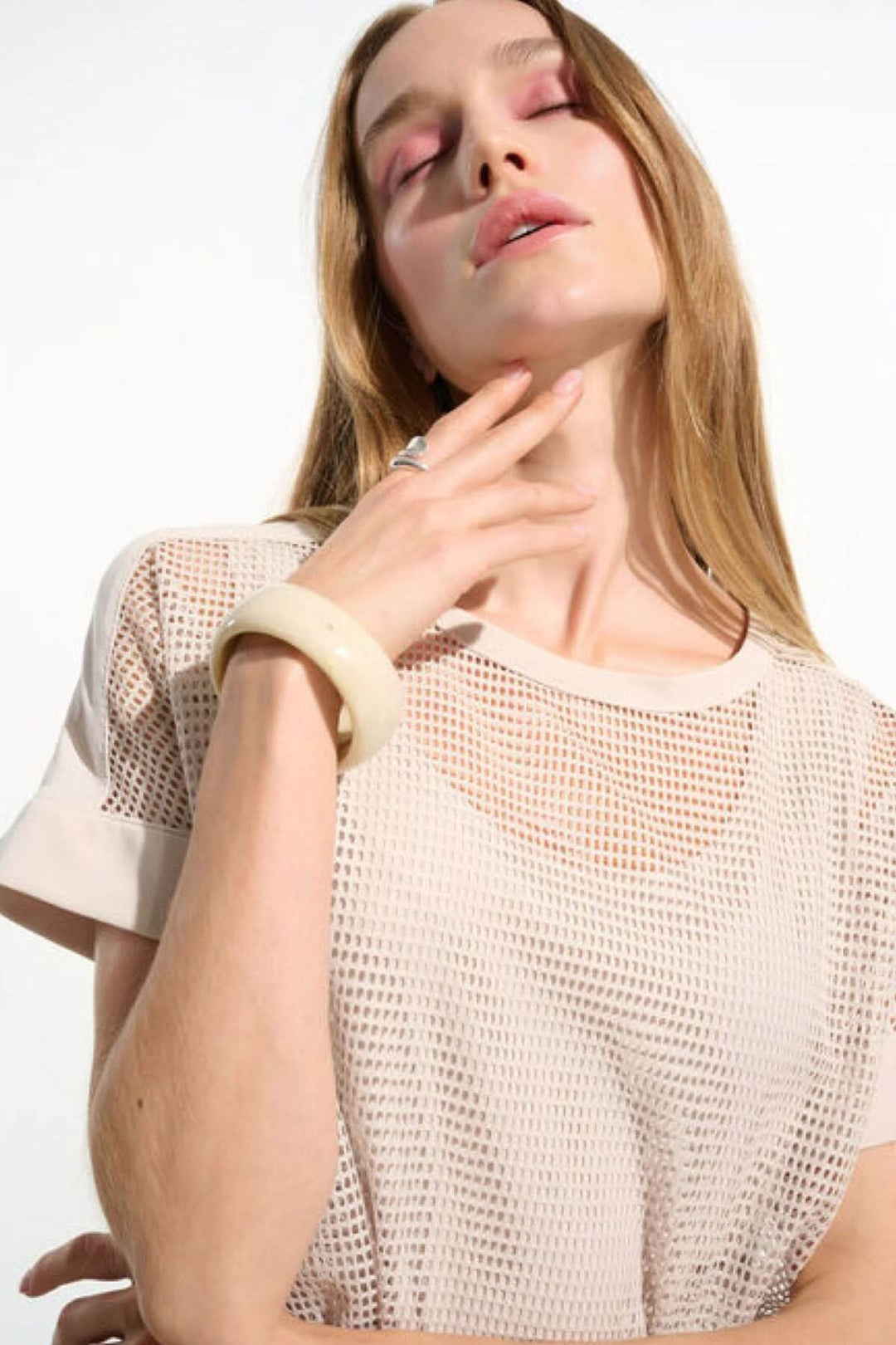 T-shirt ajouré fluide avec manches courtes à revers et maille quadrillée, porté par une femme pour un style contemporain