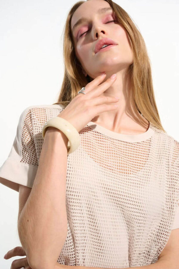 T-shirt ajouré fluide avec manches courtes à revers et maille quadrillée, porté par une femme pour un style contemporain
