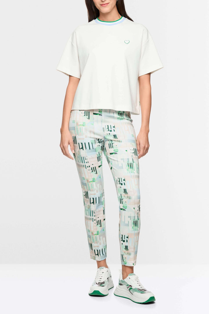 Femme portant un t-shirt avec détails en forme de cœur et à rayures, coupe ample, manches larges, encolure ronde avec liseré contrastant.