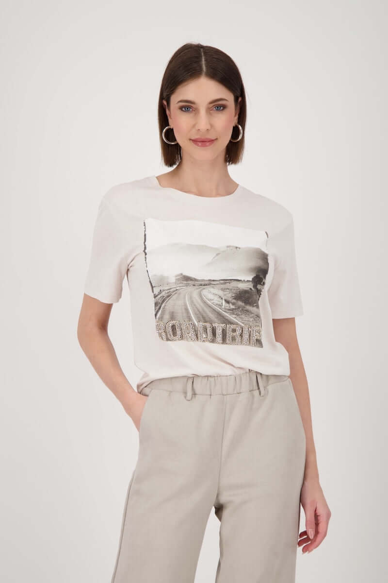 Femme portant un T-shirt imprimé avec motif photo "road trip" pour un style casual chic.