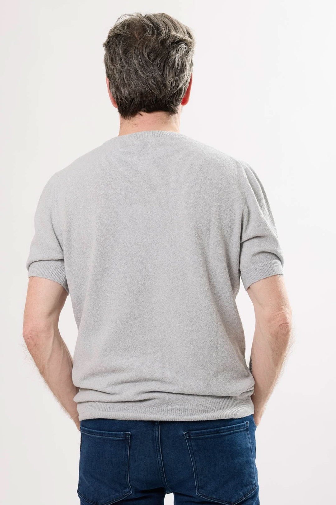 Homme portant un t-shirt gris élégant, vue de dos, avec des manches courtes et un col rond.